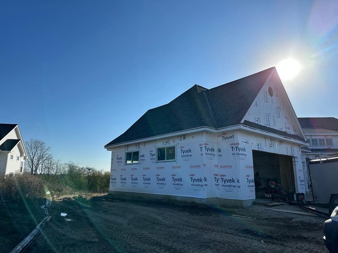 Completed new home at dusk, gables and attached garage in low sun