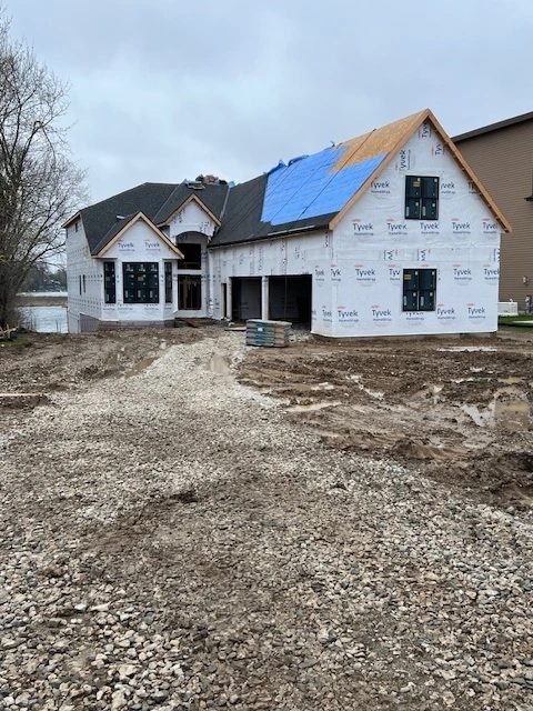 New home framed, wrapped, and roofed, with the windows set