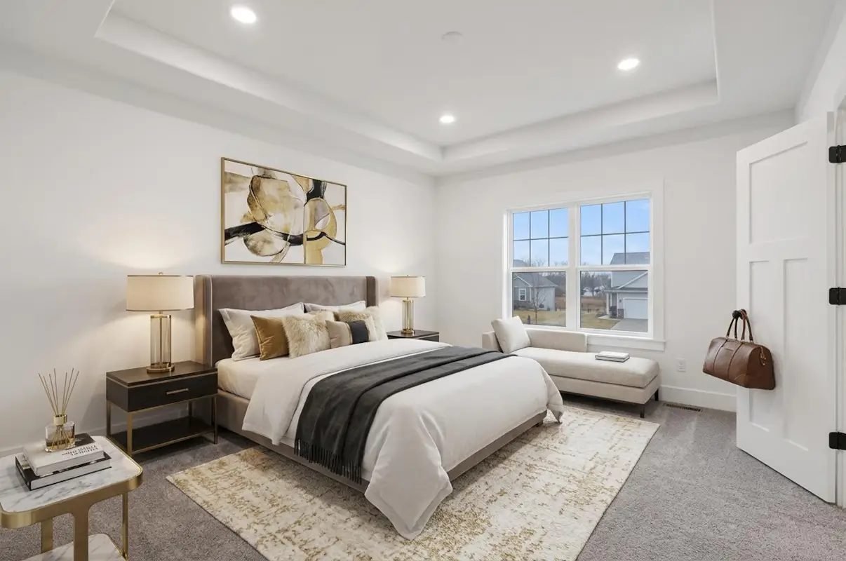 Primary bedroom with a stepped tray ceiling and windows on two walls