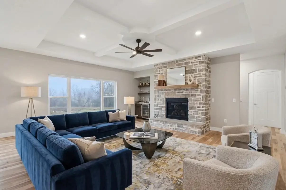 Living room with a floor-to-ceiling stone fireplace and a coffered ceiling