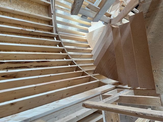 Rafters and roof framing seen from below, evenly spaced and braced