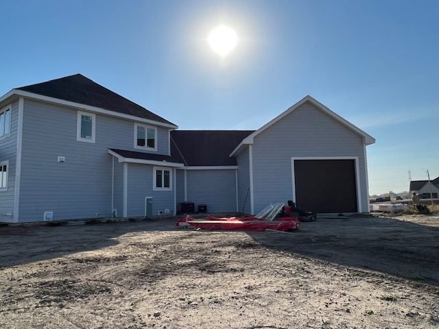 Sided new home with the driveway poured and grading underway