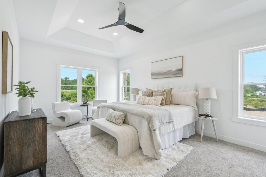 Primary bedroom with a tray ceiling and corner windows